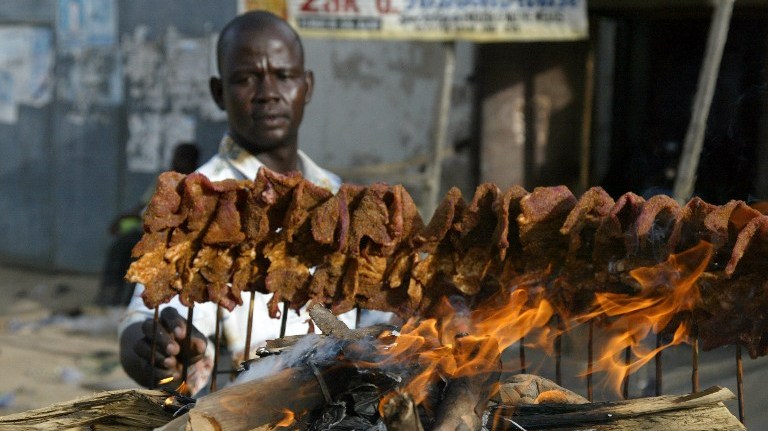 A man arranges sticks of meat on a mud platform for roasting in the ancient city of Kano 19 April, 2007. Roasted meat on sticks popularly known as 'Suya' is a common delicacy in northern Nigeria. AFP PHOTO PIUS UTOMI EKPEI