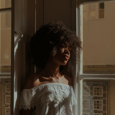 woman leaning on a window, sad